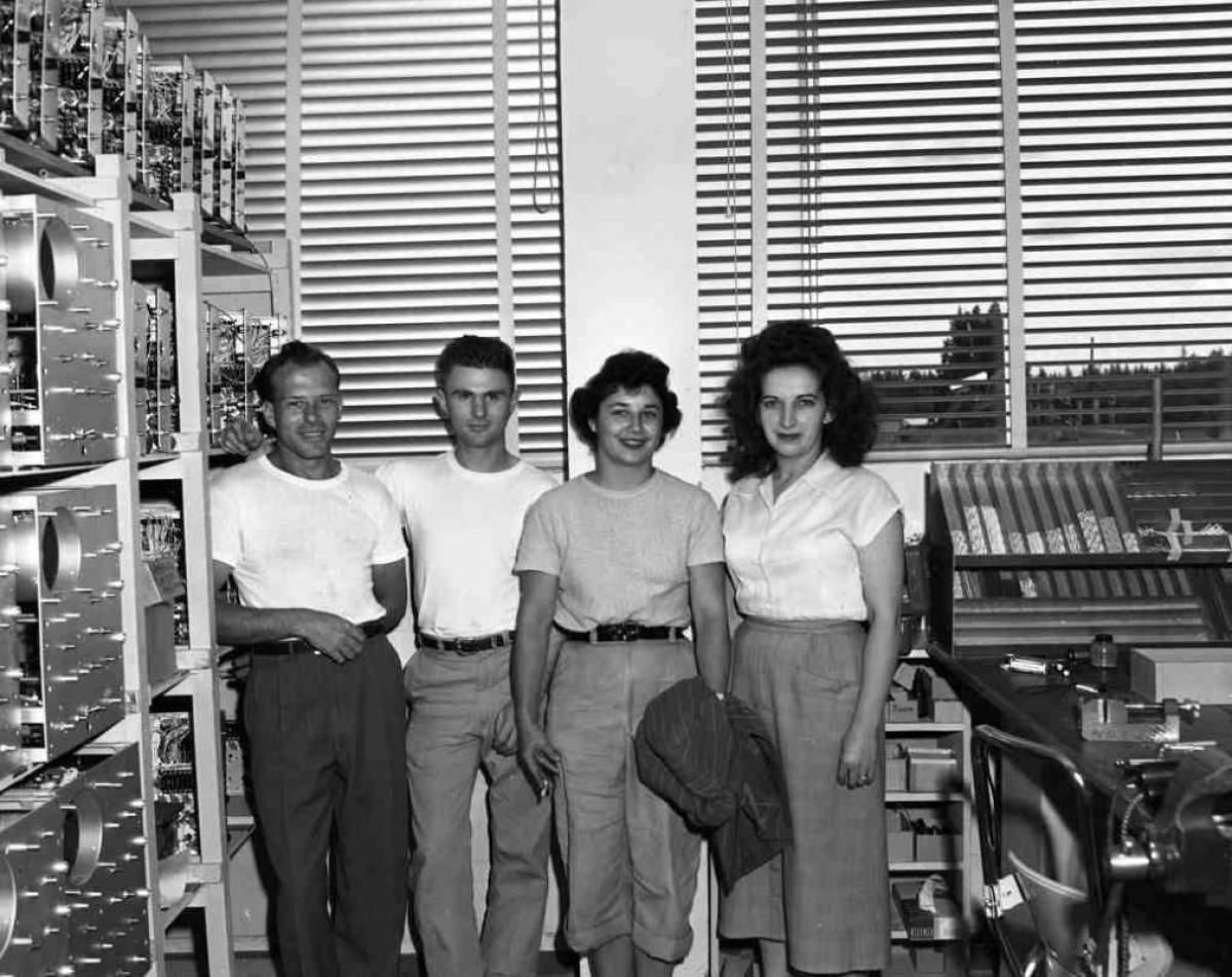 black and white photo of two male and two female HR professionals smiling